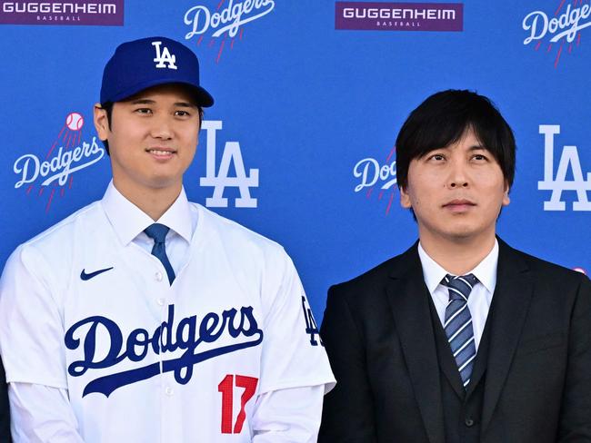 (FILES) Japanese baseball player Shohei Ohtani (C) poses with his agent Nez Balelo (L) and Japanese interpreter Ippei Mizuhara during a press conference on his presentation after signing a ten-year deal with the Los Angeles Dodgers at Dodgers Stadium in Los Angeles, California on December 14, 2023. Representatives of Shohei Ohtani said March 20, 2024 the baseball superstar had been the victim of "a massive theft," reported to involve millions of dollars allegedly stolen by the Japanese ace's interpreter to place bets with a suspected illegal bookmaker. The Los Angeles Times reported that the firm had looked into the actions of Ohtani's longtime interpreter Ippei Mizuhara after the newspaper learned that Ohtani's name had surfaced in a federal investigation of alleged illegal bookmaker Mathew Bowyer. (Photo by Frederic J. Brown / AFP)
