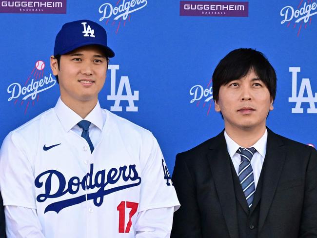 (FILES) Japanese baseball player Shohei Ohtani (C) poses with his agent Nez Balelo (L) and Japanese interpreter Ippei Mizuhara during a press conference on his presentation after signing a ten-year deal with the Los Angeles Dodgers at Dodgers Stadium in Los Angeles, California on December 14, 2023. Representatives of Shohei Ohtani said March 20, 2024 the baseball superstar had been the victim of 