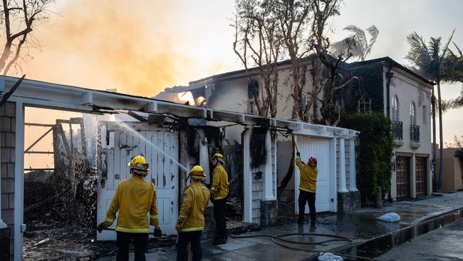 Firefighters douse a beach house destroyed by the Palisades fire. Picture: Zoa Meyers/AFP