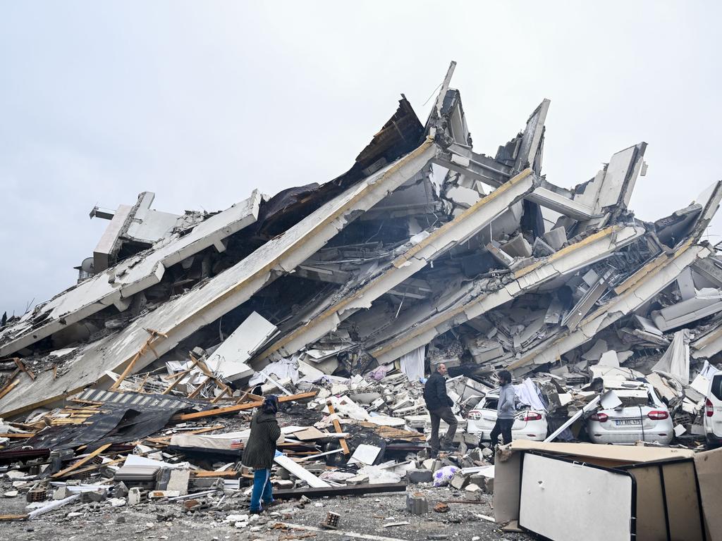 Survivors walk among ruined buildings in Hatay, Turkey. Picture: Getty