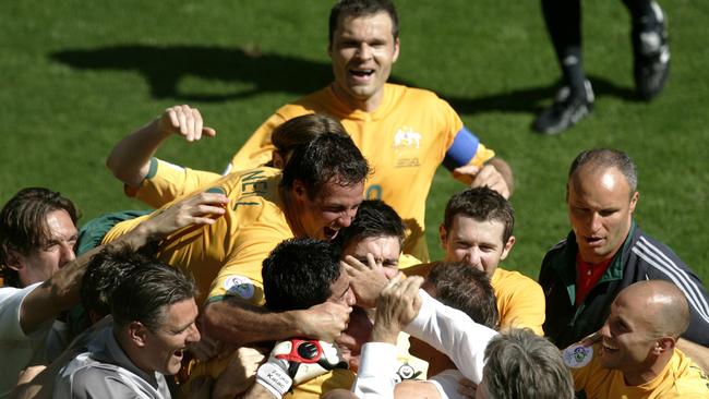 12/06/2006. Australian Socceroos coach Guus Hiddink, (bottom white shirt), celebrates with his players after John Aloisi scored his side's third goal during their World Cup Group F soccer match against Japan in Kaiserslautern, Germany. (AP Photo/Emilio Morenatti) ** MOBILE/ PDA USAGE OUT **