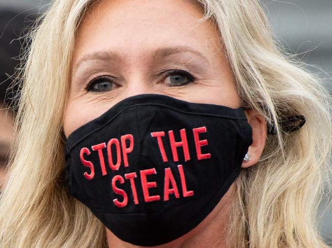 (FILES) In this file photo taken on January 4, 2021 US Representative Marjorie Taylor Greene, Republican of Georgia, holds up a "Stop the Steal" mask while speaking with fellow first-term Republican members of Congress on the steps of the US Capitol in Washington, DC. - Rep. Marjorie Taylor Greene of Georgia annnounced on Twitter that she had filed articles of impeachment against US President Joe Biden on January 21, 2021. (Photo by SAUL LOEB / AFP)