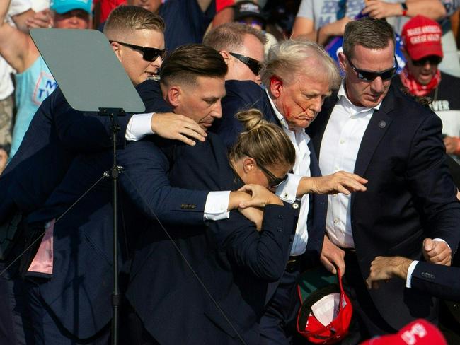 Republican candidate Donald Trump is helped to his feet by Secret Service agents. Picture: AFP