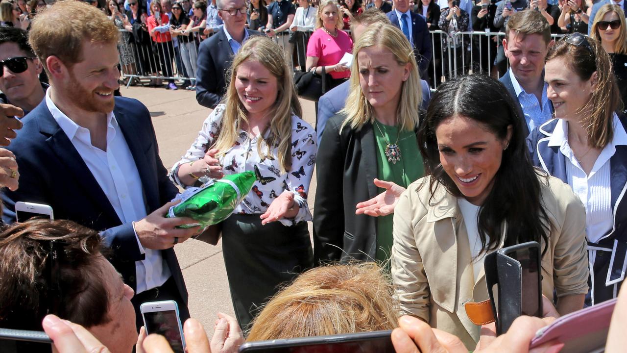 Amy Pickerill, second from left, reaches out to take a green parcel from Prince Harry. Picture: Nathan Edwards