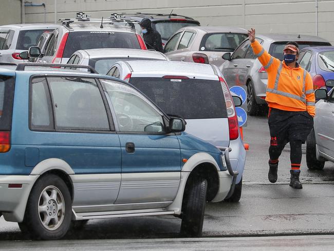 WELLINGTON, NEW ZEALAND - AUGUST 18: A staff member organises traffic at a COVID-19 testing station during the first day of a national lockdown on August 18, 2021 in Wellington, New Zealand. Level 4 lockdown restrictions have come into effect across New Zealand for the next three days, while Auckland and the Coromandel Peninsula will remain in lockdown for seven days after a positive COVID-19 case was confirmed in the community in Auckland on Tuesday. The positive case traveled to Coromandel over the weekend and the source of the infection is still unknown. New Zealand health officials are also yet to confirm whether it is the highly contagious Delta variant of the coronavirus. Under COVID-19 Alert Level 4 measures, people are instructed to stay at home in their bubble other than for essential reasons, with travel severely limited. All non-essential businesses are closed, including bars, restaurants, cinemas and playgrounds. All indoor and outdoor events are banned, while schools have switched to online learning. Essential services remain open, including supermarkets and pharmacies. (Photo by Hagen Hopkins/Getty Images)