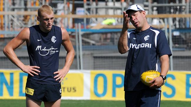 A young Mitch Robinson talks with coach Brett Ratten at the end of training during his playing days at Carlton.