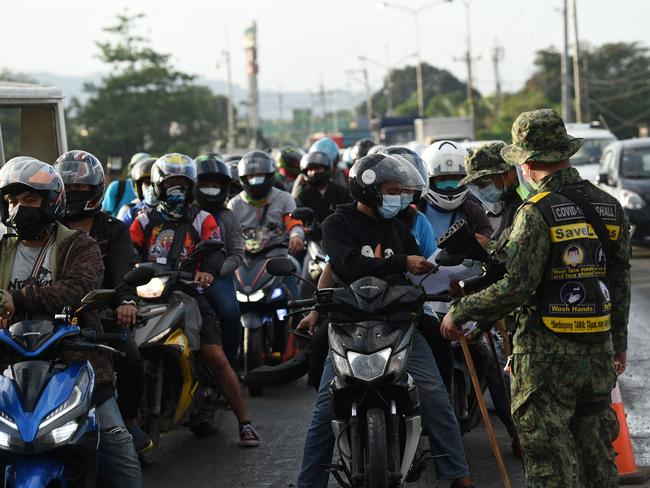 Policemen checking documents of motorists travelling from the nearby province of Rizal at a border check point in Quezon City, suburban Manila. Picture: AFP