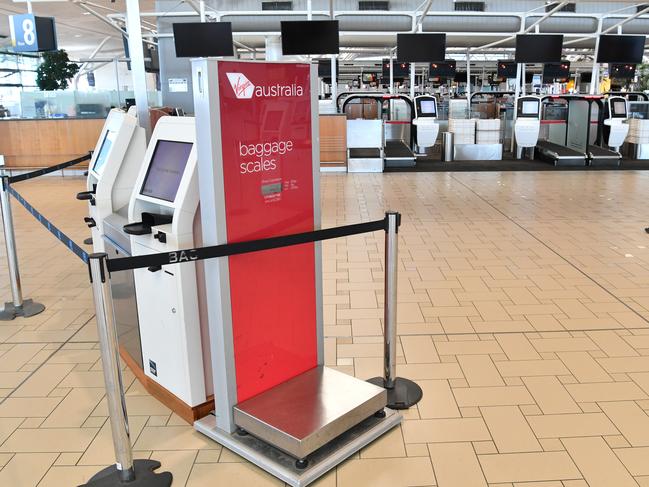 Empty Virgin Australia check-in counters are seen at Brisbane International Airport in Brisbane last Friday. Picture: Darren England