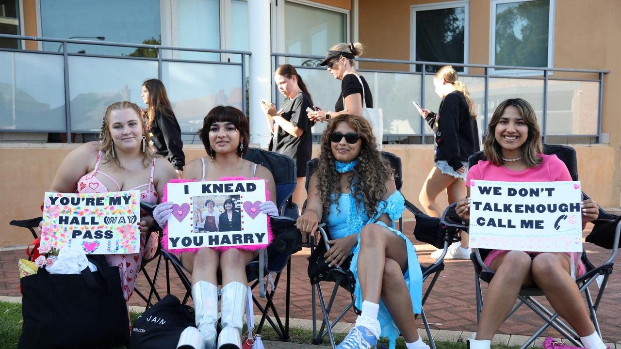 Fans waiting outside the venue with signs. Picture: NCA NewsWire /Philip Gostelow