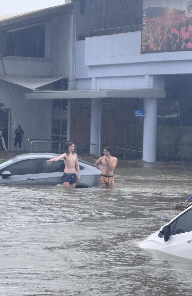 Timmy Rhodes took this image of good Samaritans checking cars in the RSL carpark as flash flooding hit Hervey Bay during the wild weather brought by ex-Tropical Cyclone Alfred.