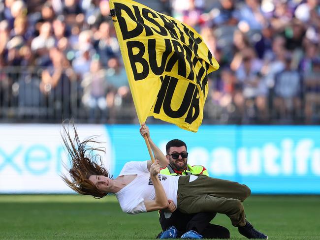 PERTH, AUSTRALIA - MAY 20: A pitch invader is tackled to the ground by a security guard during the round 10 AFL match between Walyalup/Fremantle Dockers and Geelong Cats at Optus Stadium, on May 20, 2023, in Perth, Australia. (Photo by Paul Kane/Getty Images)