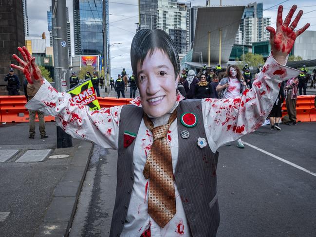 Protesters wear Penny Wong masks. Picture: Jake Nowakowski