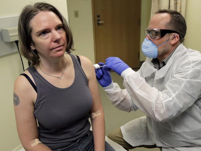 FILE - In this March 16, 2020, file photo, a pharmacist gives Jennifer Haller, left, the first shot in the first-stage safety study clinical trial of a potential vaccine for COVID-19, the disease caused by the new coronavirus, at the Kaiser Permanente Washington Health Research Institute in Seattle. The vaccine by Cambridge, Massachusetts-based Moderna Inc., generated antibodies similar to those seen in people who have recovered from COVID-19 in a study volunteers who were given either a low or medium dose. (AP Photo/Ted S. Warren, File)