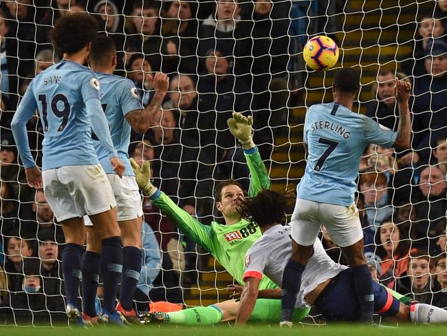 TOPSHOT - Manchester City's English midfielder Raheem Sterling (R) scores their second goal for 2-1 past Bournemouth's Bosnian-Herzegovinian goalkeeper Asmir Begovic (C) during the English Premier League football match between Manchester City and Bournemouth at the Etihad Stadium in Manchester, north west England, on December 1, 2018. (Photo by Oli SCARFF / AFP) / RESTRICTED TO EDITORIAL USE. No use with unauthorized audio, video, data, fixture lists, club/league logos or 'live' services. Online in-match use limited to 120 images. An additional 40 images may be used in extra time. No video emulation. Social media in-match use limited to 120 images. An additional 40 images may be used in extra time. No use in betting publications, games or single club/league/player publications. /