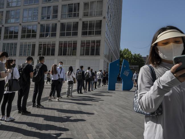 Office workers wait in line to show their health codes and proof of 48 hour negative nucleic acid test, outside an office building after some people returned to work in Beijing. Picture: Getty Images