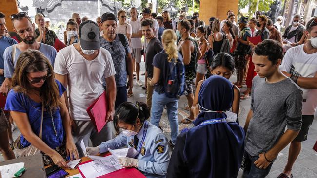 Foreigners queue to extend their tourist visas at the Ngurah Rai Immigration Office in Jimbaran, Bali