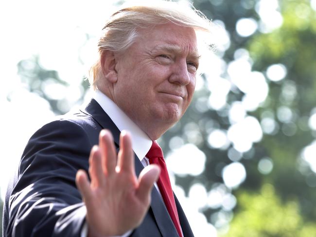 US President Donald Trump waves as he walks out from the White House in Washington before his departure to Norfolk, Virginia on July 22, 2017. / AFP PHOTO / YURI GRIPAS