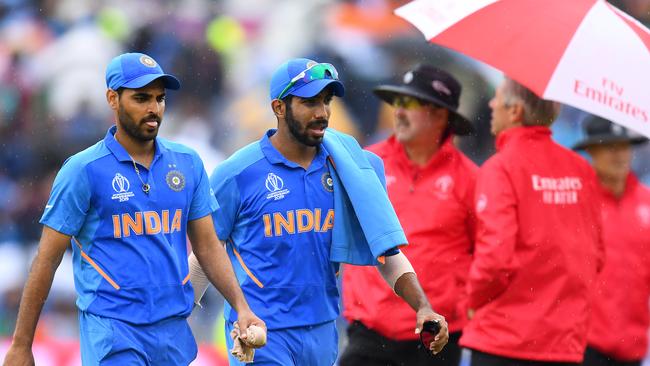 Bhuvneshwar Kumar and Jasprit Bumrah leave the pitch as rain halts play. Picture: Getty