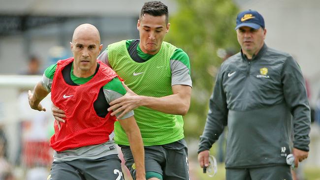 Socceroos train ahead of their Asian Cup opener at Olympic Park, Mark Bresciano and Jason Davidson contest under the watchful eye of coach Ange Postecoglou. Melbourne. 4th January 2015. Picture: Colleen Petch.