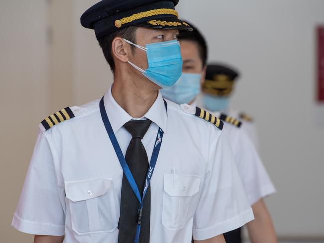 Passengers and crew arriving in Adelaide on the China Southern Airlines flight from Guangzhou wear face masks. Picture: Brad Fleet