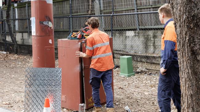 Workers fix a damaged electrical box that controls security lighting in Kurilpa Park.