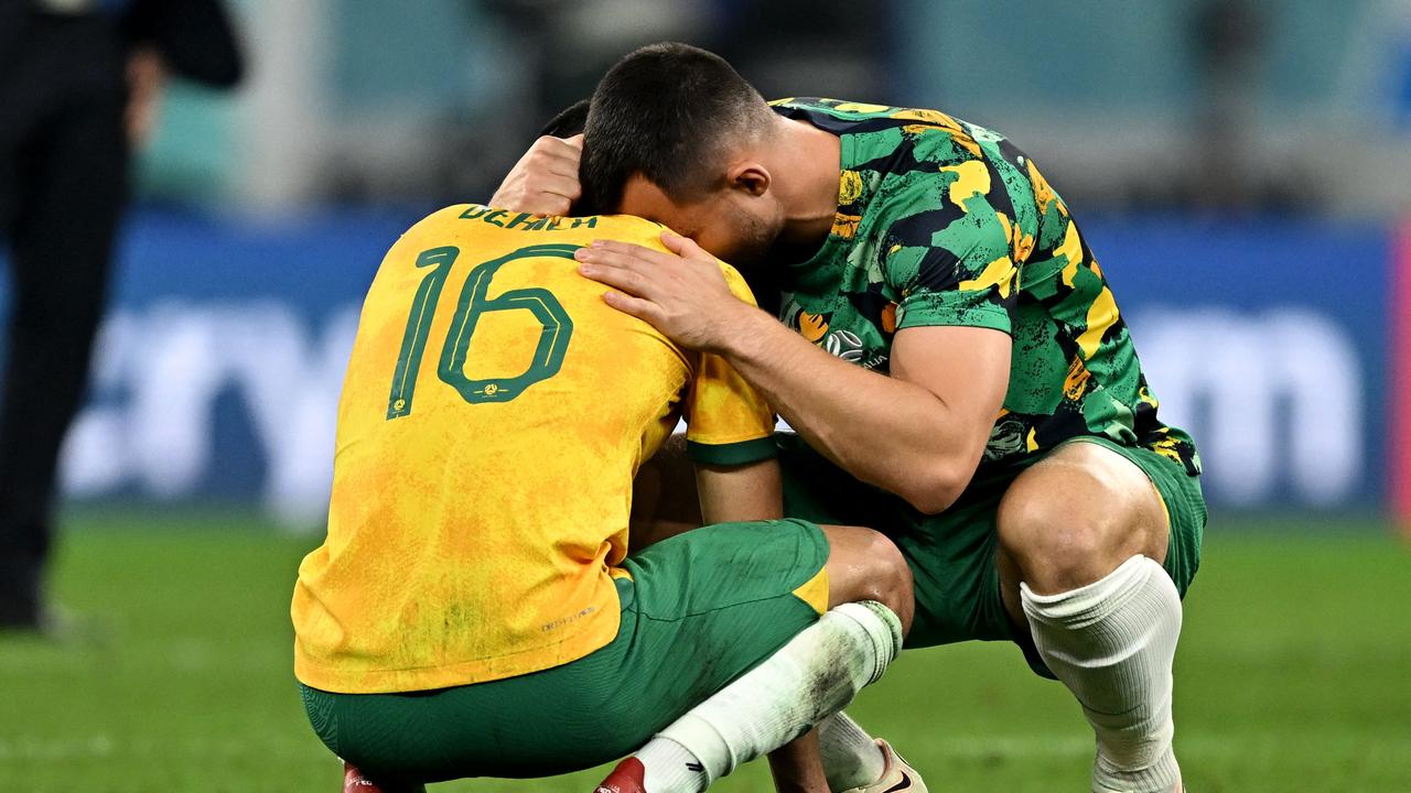 Australia's defender #16 Aziz Behich is comforted with a teammate after losing 2-1 to Argentina in the Qatar 2022 World Cup round of 16 football match between Argentina and Australia at the Ahmad Bin Ali Stadium in Al-Rayyan, west of Doha on December 3, 2022. (Photo by MANAN VATSYAYANA / AFP)