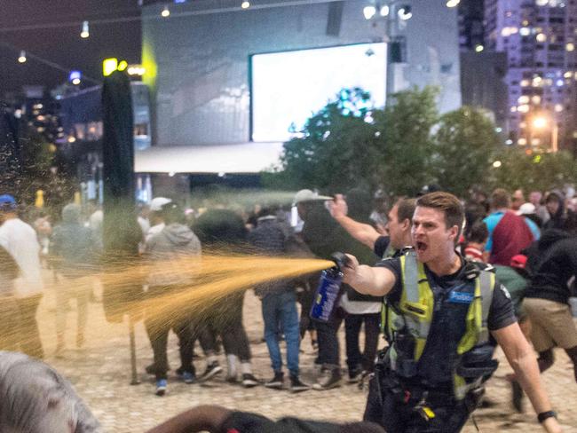 A police officer uses capsicum spray during the Moomba riots. Picture: Jake Nowakowski