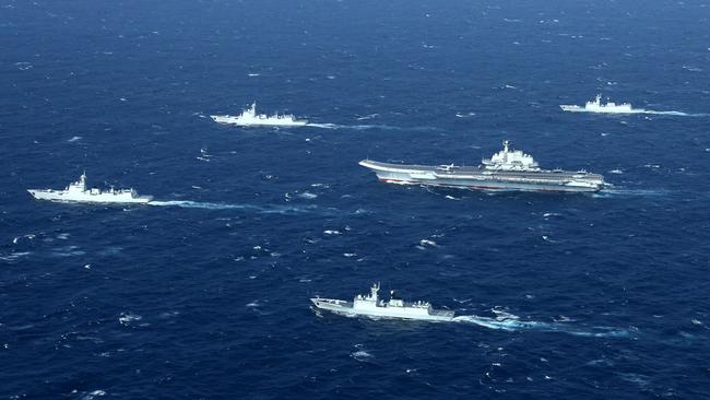 This aerial photo shows a Chinese navy formation, including the aircraft carrier Liaoning, centre, during military drills in the South China Sea. Picture: AFP