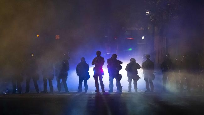 Federal officers walk through teargas while dispersing a crowd of about a thousand people during a protest in Portland, Oregon. Picture: AFP