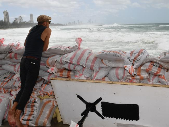 Rick Shores Restaurant staff member Mario Wanagat is seen sandbagging the front of the restaurant in an attempt to protect it from the oncoming waves at Burleigh Heads  on the Gold Coast, Saturday, February 23, 2019. Huge swells and high tides are pummelling south-east Queensland beaches as Cyclone Oma sits off the Queensland coast. (AAP Image/Darren England) NO ARCHIVING