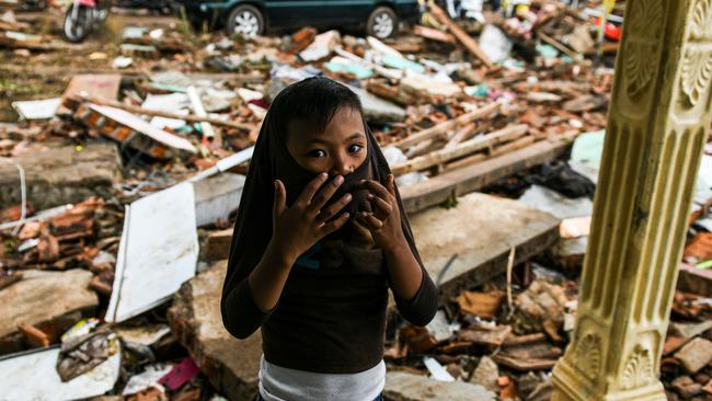 A boy stands outside a collapsed house in the Lampung province. Picture: AFP