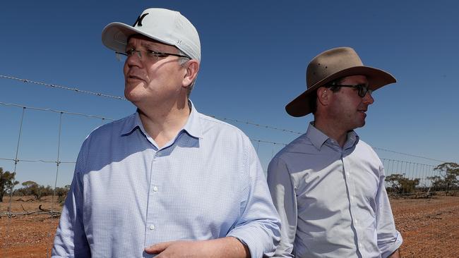 Prime Minister Scott Morrison (in his Hurley cap) and Minister for Agriculture and Water Resources David Littleproud (on message) during a regional tour in Quilpie yesterday.