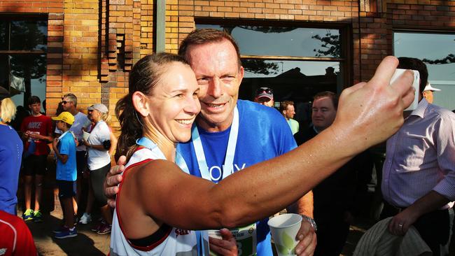 Tony Abbott poses for selfies after completing the Manly Scenic 10km Fun Run. Pollsters predict his tally of votes will slide at the July 2 election. But will it be by enough for him to lose the seat? Picture: Braden Fastier