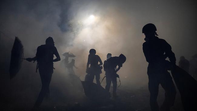 Anti-government protesters stand in a cloud of tear gas unleashed during a stand off with riot police at the Chinese University of Hong Kong, in 2019. Picture: Reuters