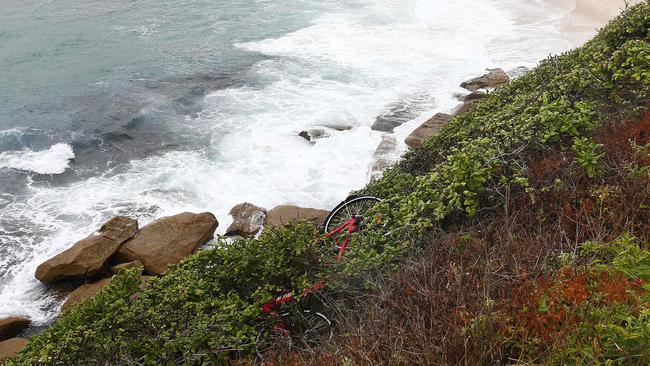 A bike thrown over the edge of the fence at Bronte Marine Drive overlooking Bronte Beach. Picture: John Appleyard