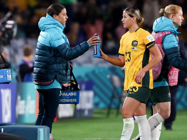 Australia's forward #20 Sam Kerr (C), ruled out due to injury, hands out water bottles to teammates at half time during the Australia and New Zealand 2023 Women's World Cup Group B football match between Australia and Ireland at Stadium Australia, also known as Olympic Stadium, in Sydney on July 20, 2023. (Photo by DAVID GRAY / AFP)