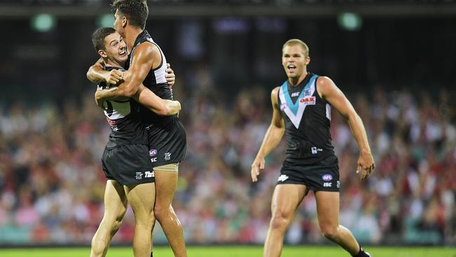 Riley Bonner celebrates his match-sealing goal against Sydney with defensive teammates Darcy Byrne-Jones (left) and Dan Houston. Picture: Brett Hemmings (AFL Media/Getty Images).