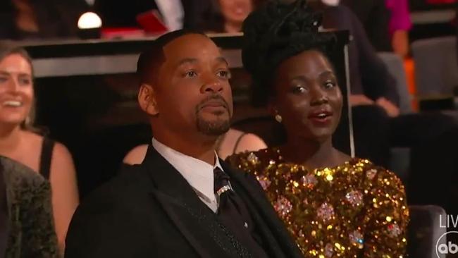 Will Smith returned to his seat and yelled at Rock - actress Lupita Nyong’o (right) looked stunned.