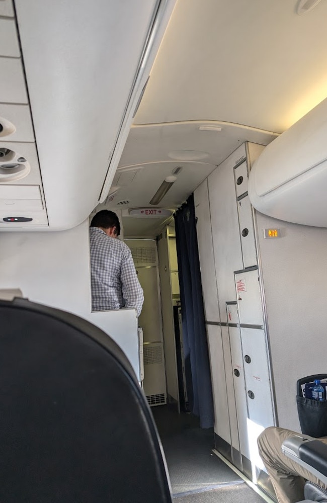 On the left of where this man (not the passengers in question) is standing is the emergency exit door and just in front of him to the left is the toilet. Picture: news.com.au