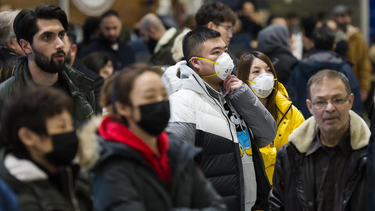 People wear masks following the outbreak of a new virus as people arrive from the International terminal at Toronto Pearson International Airport in Toronto. Picture: Nathan Denette/The Canadian Press via AP