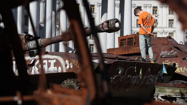 A boy stands on a destroyed Russian tank on display at Mykhailivska Square in Kyiv, on September 7, 2024, amid the Russian invasion in Ukraine. (Photo by Anatolii STEPANOV / AFP)