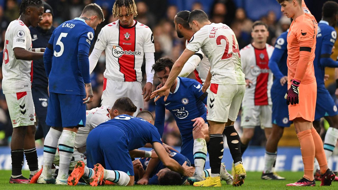 Players from both sides show concern for Cesar Azpilicueta. (Photo by Glyn KIRK / AFP)