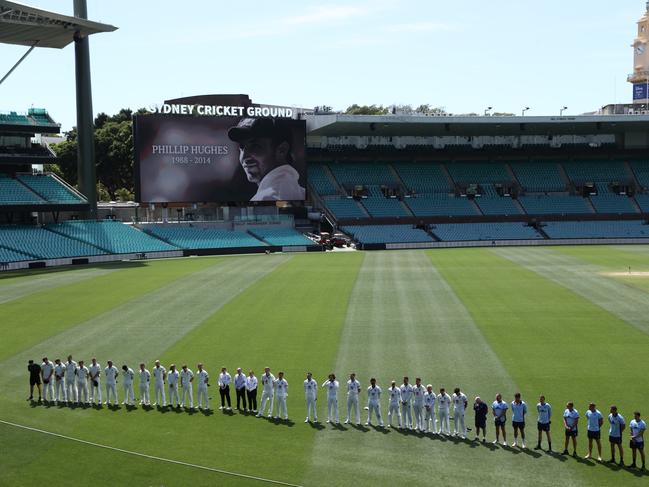 Umpires, players and staff from New South Wales and Tasmania commemorate the life of Phillip Hughes with a minutes on Wednesday. Picture: Jason McCawley/Getty Images.