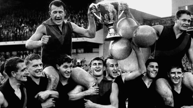 Melbourne captain John Beckwith and vice-captain Ron Barassi are chaired off with the 1959 Premiership Cup by (from left) Hassa Mann, Ian Ridley, Brian Dixon, Ian Thorogood, Peter Brenchley, Geoff Case, Clyde Laidlaw and Denis Jones.