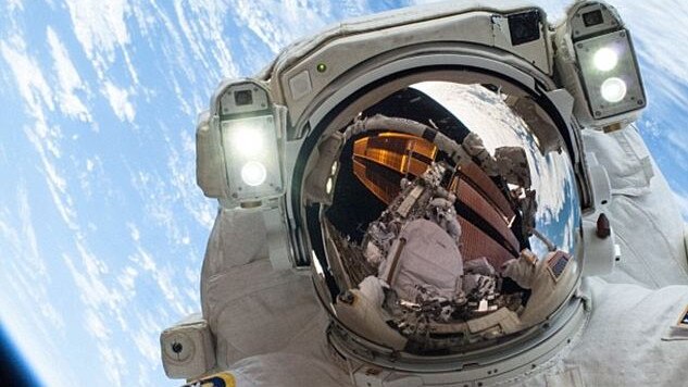 Astronaut Colonel Mike Hopkins strikes a rare pose as he helps repair the international space station.