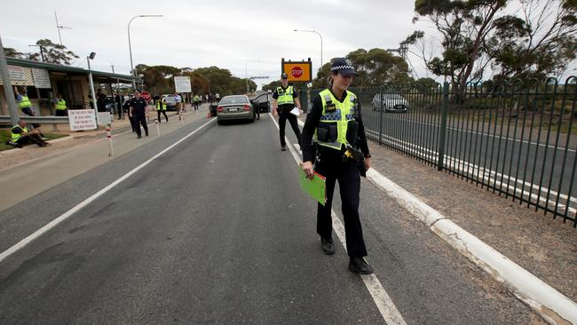 Police stop vehicles at the SA border, 5kms east of Pinnaroo, after the borders shut. Picture: AAP / Kelly Barnes