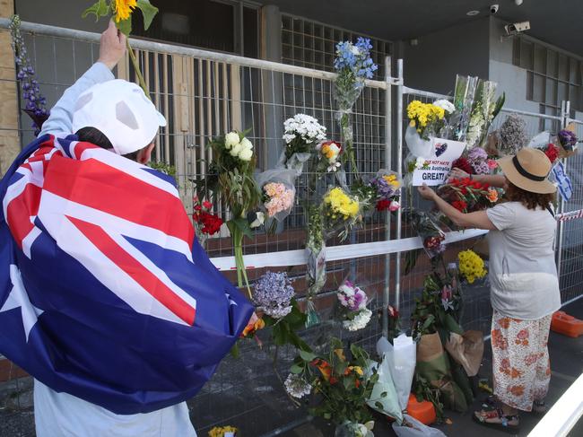 People add to the flowers left at the synagogue. Picture: David Crosling