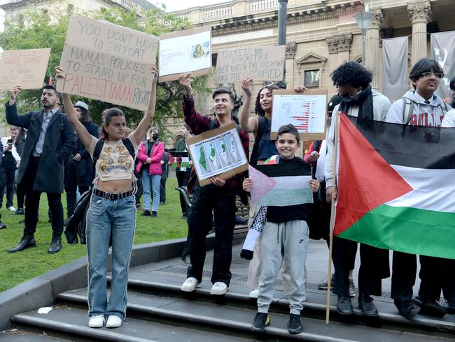 People hold signs at the event. Picture: Andrew Henshaw