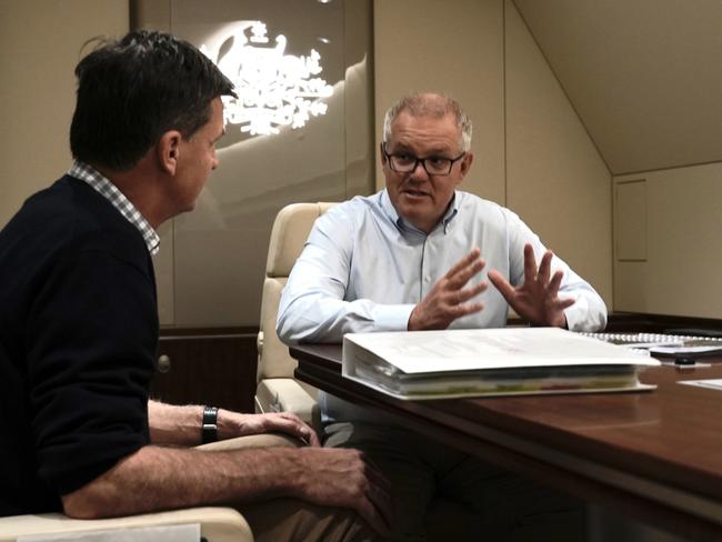 Prime Minister Scott Morrison and Energy Minister Angus Taylor chat in the boardroom on the way to the G20 in Rome. Picture: Adam Taylor/PMO