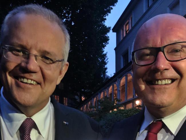 Scott Morrison with George Brandis holding the digital Courier Mail front page from the State of Origin Queensland win